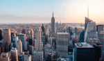 The Freeman Studio Aerial view of New York City skyline featuring numerous skyscrapers, including the Empire State Building, with a clear sky in the background. New York & Toronto Acting Studio