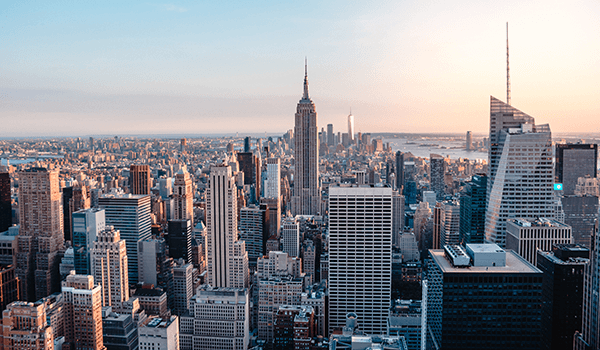 The Freeman Studio Aerial view of New York City skyline featuring numerous skyscrapers, including the Empire State Building, with a clear sky in the background. New York & Toronto Acting Studio