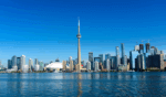 The Freeman Studio Toronto skyline with the CN Tower and modern high-rise buildings, viewed from across the water under a clear blue sky. New York & Toronto Acting Studio