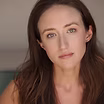 The Freeman Studio A woman with long brown hair looks directly at the camera with a neutral expression, set against a blurred background. New York & Toronto Acting Studio