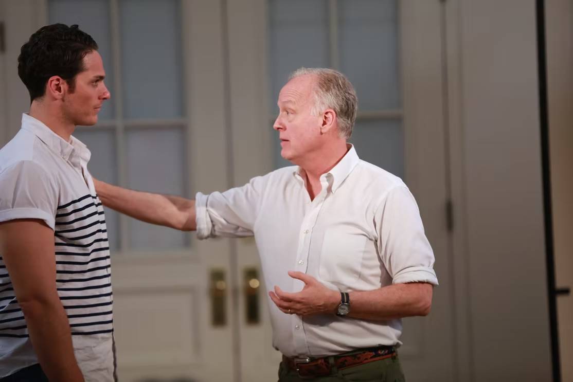 The Freeman Studio Two men stand indoors facing each other; one older man has his hand on the younger man's shoulder as they talk. New York & Toronto Acting Studio